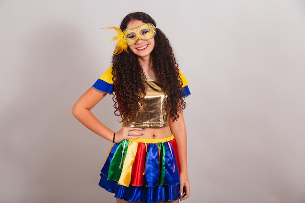 Foto joven adolescente brasileña con frevo ropa carnaval máscara manos en las caderas