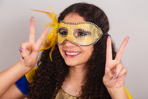 Joven adolescente brasileña con ropa de frevo máscara de carnaval foto de primer plano paz y amor