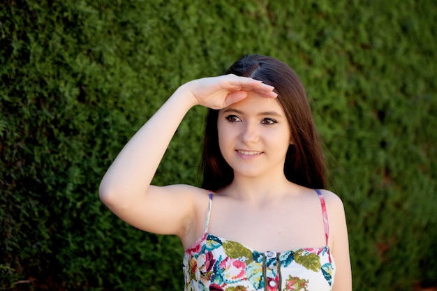 Joven adolescente buscando algo al aire libre