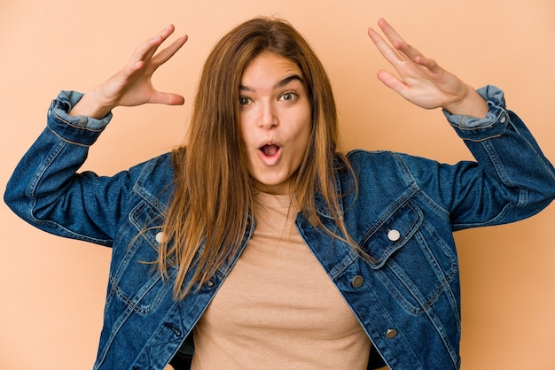 Joven adolescente caucásica flaca celebrando una victoria o un éxito, se sorprende y se sorprende.