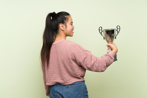 Joven adolescente chica asiática sosteniendo un trofeo