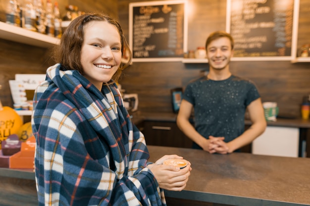 Joven adolescente comprando un café con barista