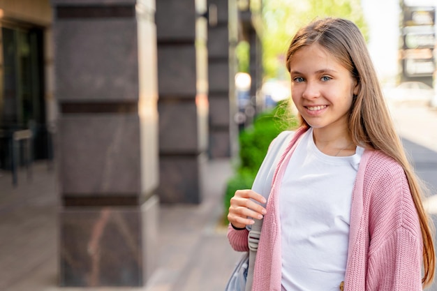 Foto una joven adolescente va a la escuela con una mochila. un estudiante adolescente o una colegiala. educación