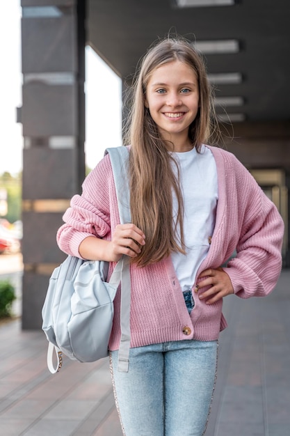 Foto una joven adolescente va a la escuela con una mochila. un estudiante adolescente o una colegiala. educación