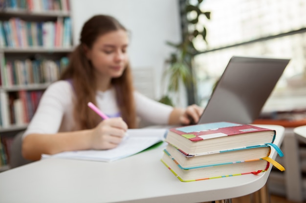 Joven adolescente estudiando en la biblioteca