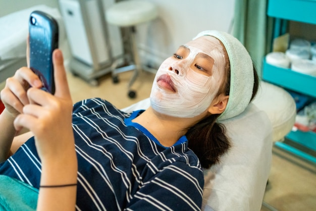 Joven adolescente femenina asiática con su teléfono inteligente