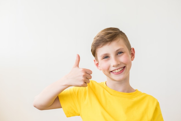 Joven adolescente fresca está posando con un pulgar arriba signo