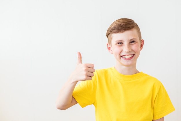 Joven adolescente fresco está posando con un pulgar hacia arriba signo