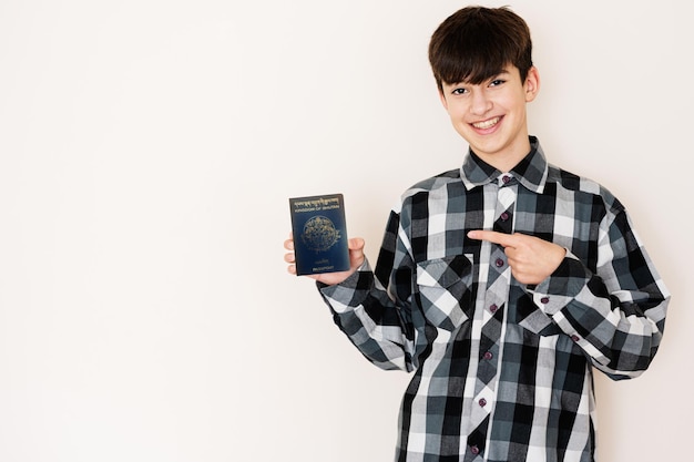 Joven adolescente con pasaporte de Bhután luciendo positivo y feliz de pie y sonriendo con una sonrisa segura contra el fondo blanco