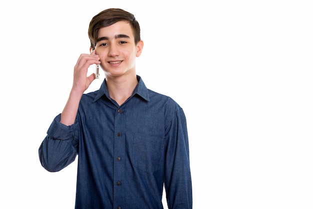 Joven adolescente persa feliz sonriendo mientras habla por teléfono móvil