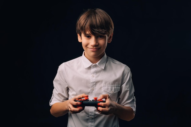 Joven adolescente sonriente con camisa blanca está jugando con un joystick