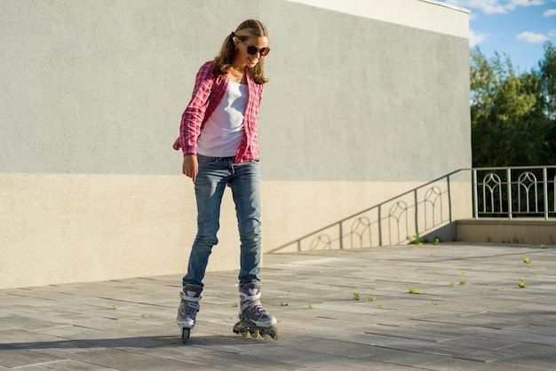 Joven adolescente sonriente niña se divierte en patines