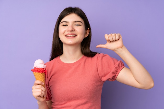 Joven adolescente sosteniendo un helado de cucurucho sobre pared púrpura orgulloso y satisfecho de sí mismo