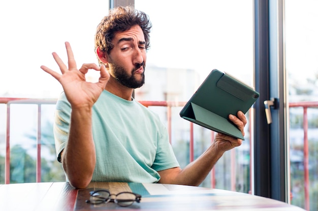 Joven adulto barbudo con un concepto de teletrabajo con pantalla táctil