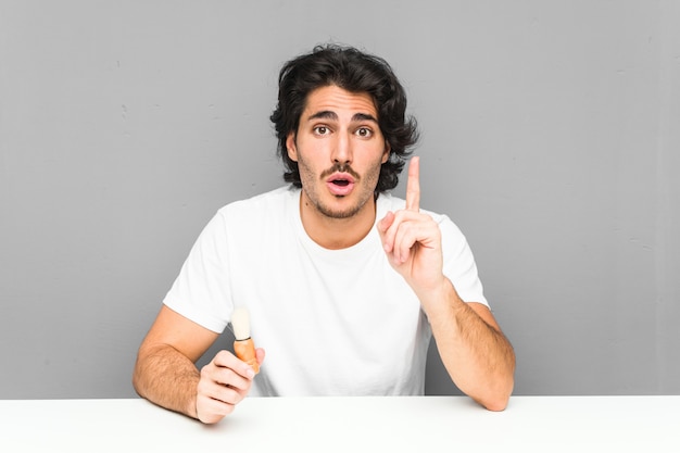 Joven afeitarse la barba teniendo una gran idea