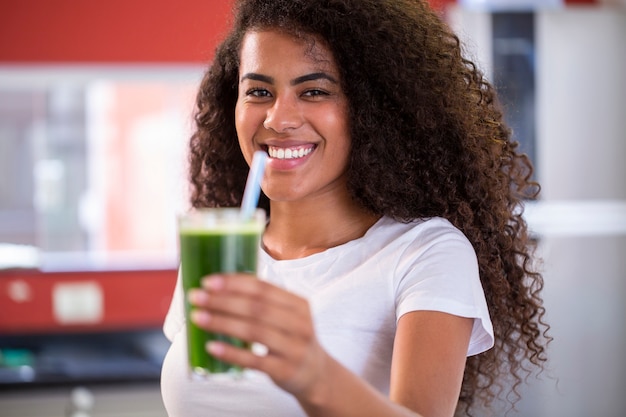 Joven africana disfruta de un batido vegetariano saludable para perder peso y desintoxicarse