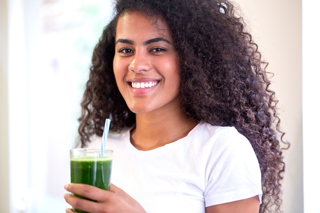 Joven africana disfruta de un batido vegetariano saludable para perder peso y desintoxicarse