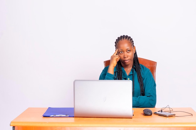 Joven africana negra sentada en el escritorio de oficina pensando en la idea.