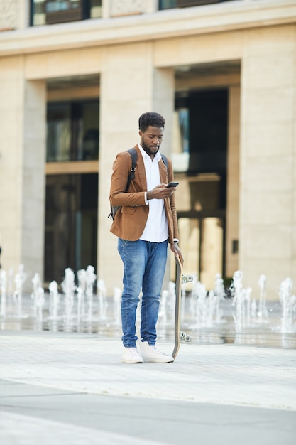 Joven africana con smartphone en la ciudad