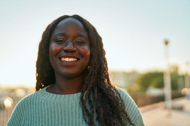 Joven africana sonriendo feliz en el parque