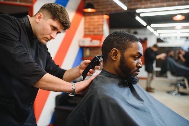 Joven africano consiguiendo nuevo corte de pelo en peluquería