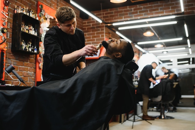 Joven africano consiguiendo nuevo corte de pelo en peluquería