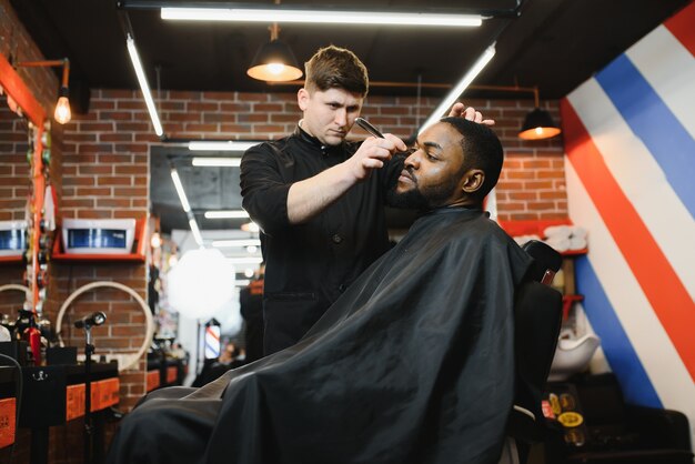 Joven africano consiguiendo nuevo corte de pelo en peluquería