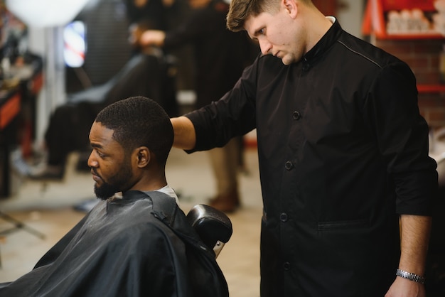 Joven africano consiguiendo nuevo corte de pelo en peluquería