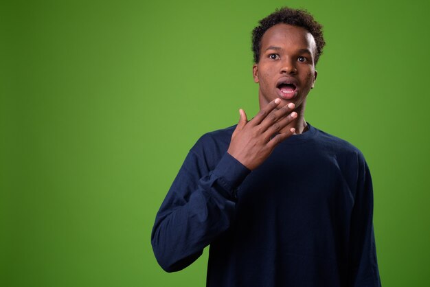 Joven africano contra la pared verde