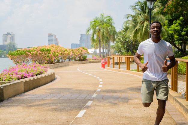 Joven africano corriendo al aire libre en el parque