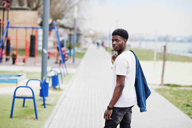 Joven africano milenario en la ciudad Hombre negro feliz en chaqueta de jeans Concepto de generación Z