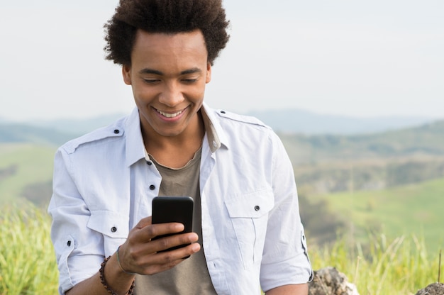 Joven africano, mirar teléfono móvil