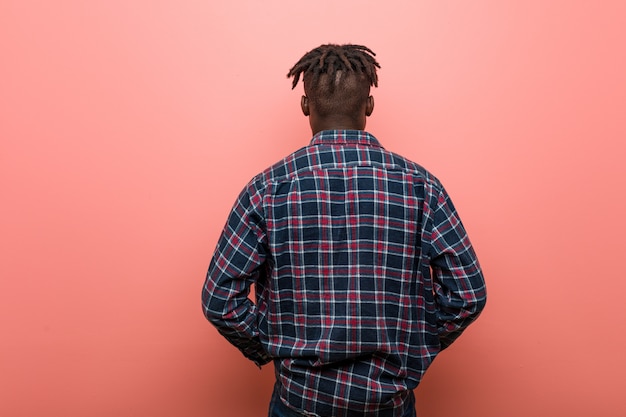 Joven africano negro desde atrás, mirando hacia atrás.