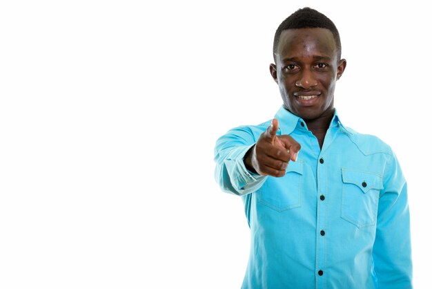 Joven africano negro feliz sonriendo mientras apunta con el dedo