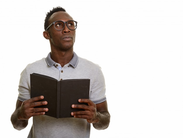 Joven africano negro sosteniendo libro mientras piensa
