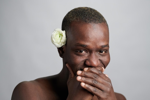 Joven africano tapándose la boca mientras se ríe