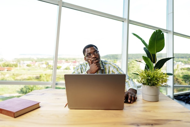Joven africano trabajando en una computadora portátil en la oficina