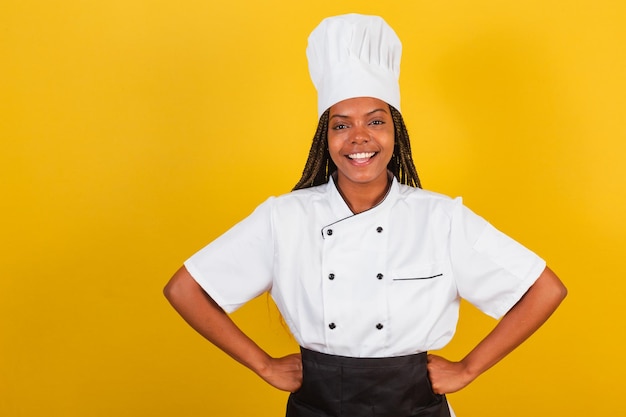 Joven afro brasileña chef cocinera con las manos en las caderas sonriendo confiado optimista