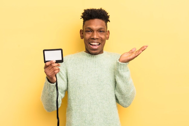 joven afro contra la pared amarilla