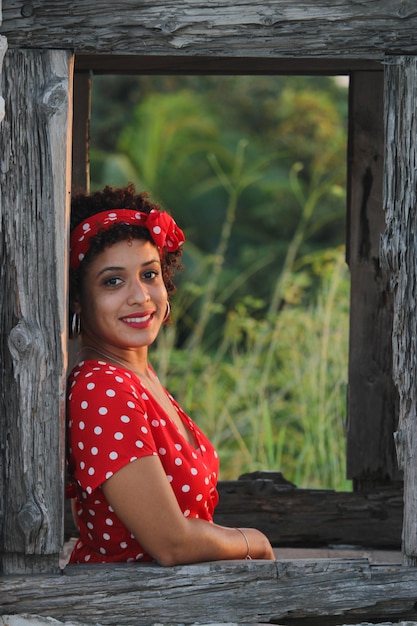 Una joven afro disfruta de la naturaleza en un parque natural La chica es joven y sonríe a la cámara