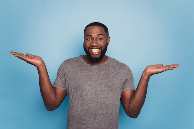 Joven afro feliz tomados de la mano aislado sobre fondo azul.