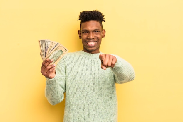 Joven afro negro apuntando a la cámara eligiendo su concepto de billetes de banco en dólares