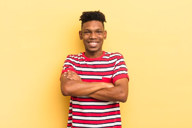 Joven afro negro que parece un feliz triunfador orgulloso y satisfecho sonriendo con los brazos cruzados