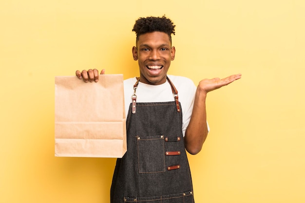 Joven afro negro que se siente feliz y asombrado por algo increíble concepto de empleado de comida para llevar