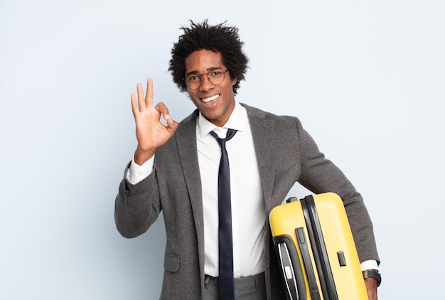 Joven afro negro que se siente feliz, relajado y satisfecho, mostrando aprobación con gesto bien, sonriendo