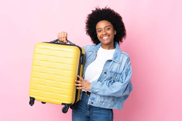 Joven afroamericana aislada con maleta de viaje