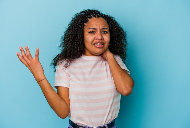 Joven afroamericana aislada en la pared azul gritando de rabia