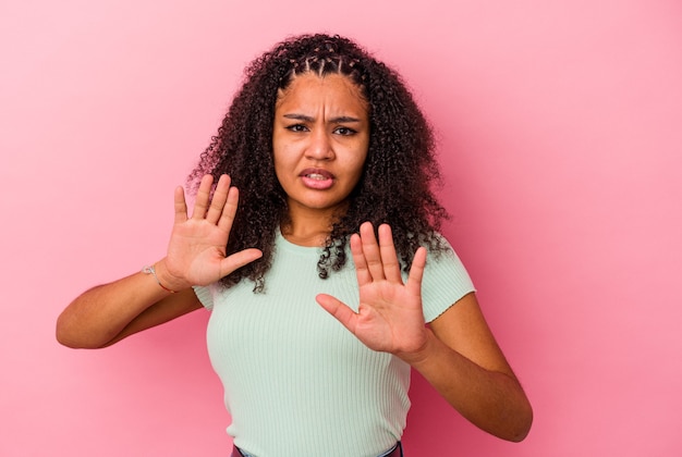 Foto joven afroamericana aislada sobre fondo rosa rechazando a alguien mostrando un gesto de disgusto.