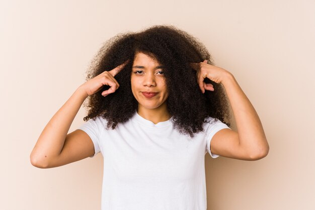 Joven afroamericana se centró en la tarea, manteniendo los índices apuntando con la cabeza.