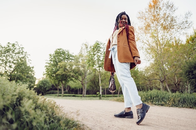 Joven afroamericana dando un paseo en un parque